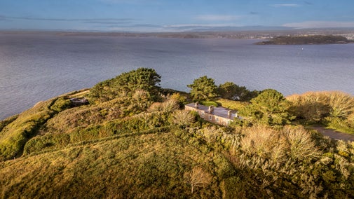 An aerial view of the back of the holiday cottages at St Anthony Head, and the surrounding headland and estuary, Cornwall